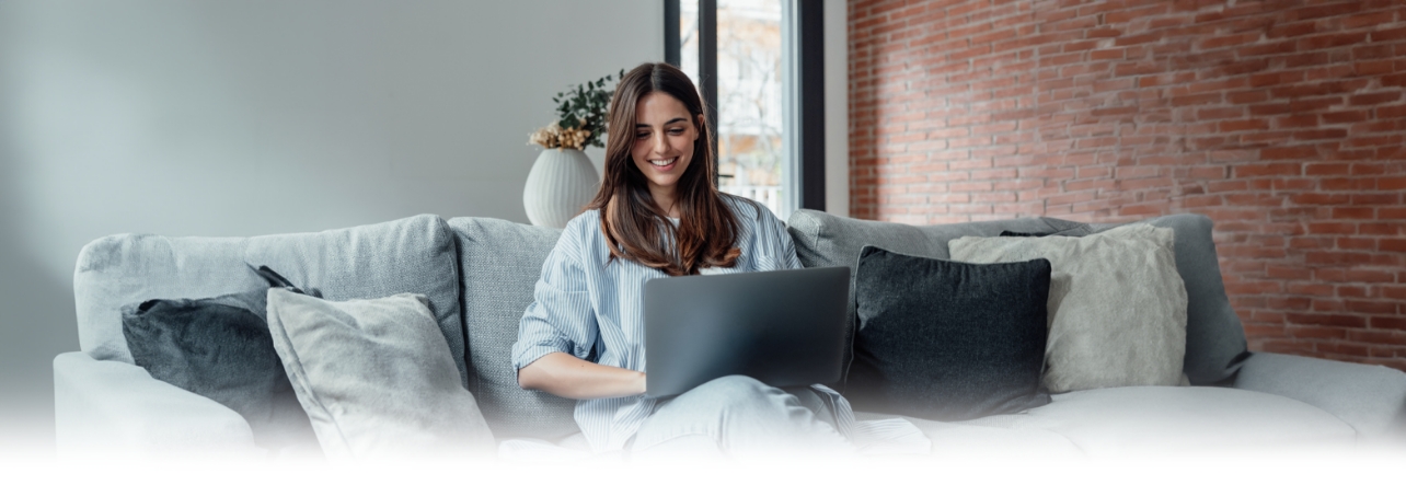 young woman on couch with laptop